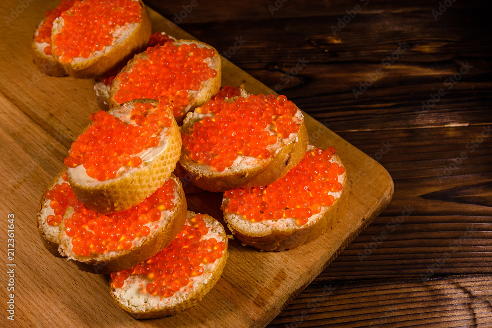 Sandwiches with red caviar on a cutting board