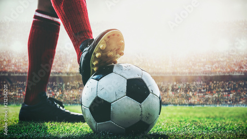 Fototapeta Naklejka Na Ścianę i Meble -  feet of soccer player tread on soccer ball for kick-off in the stadium
