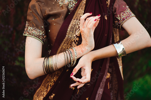 Woman Hands with black mehndi tattoo. Hands of Indian bride girl with black henna tattoos. Fashion. India © nagaets