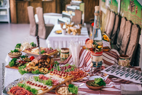 Meat assortment of sausage, smoked meat, on a wooden board on wedding table