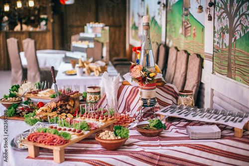 Meat assortment of sausage, smoked meat, on a wooden board on wedding table