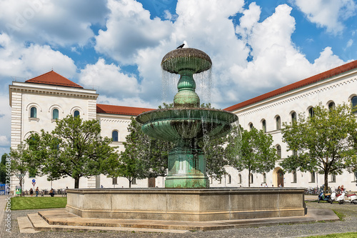Munich, Germany June 09, 2018: Fountain at Geschwister-Scholl-Platz in Munich. Tourists at the Ludwig Maximilian University of Munich. The university is among the oldest universities of Germany.