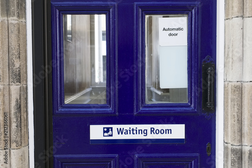 Waiting room sign on blue door at train station