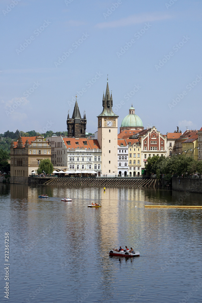 .View of the Old Town Water Tower reflected in the Vltava river with pedal boats, Prague, Czech Republic