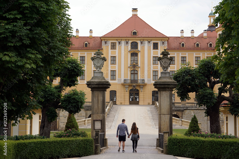 Obraz premium Young couple holding hands enters Moritzburg Castle, Saxony, Germany