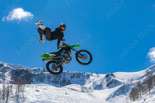 Bild auf Leinwand racer on a motorcycle in flight, jumps and takes off on a springboard against th