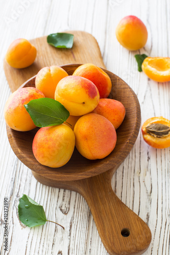 Ripe apricots in wooden bowl