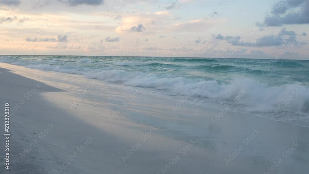 Low Angle View of Ocean Waves on White Sandy Beach at Sunrise Low Angle View of Ocean Waves on White Sandy Beach at Sunrise