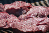 raw salted meat on a barbecue grill