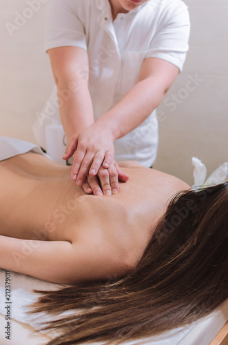 Young woman receiving back massage in beauty spa salon.