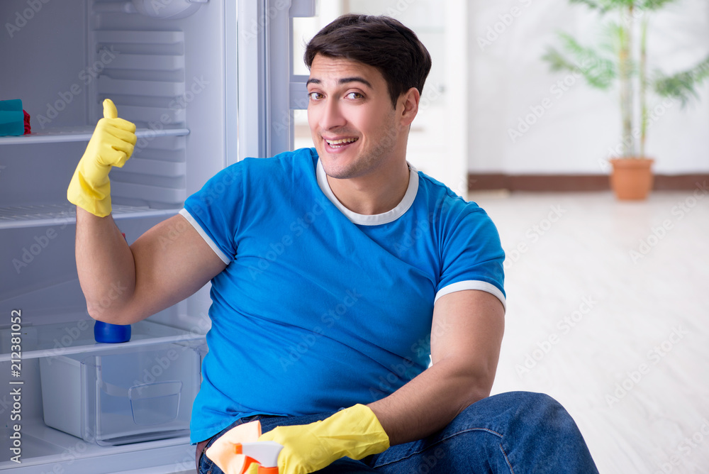 Man cleaning fridge in hygiene concept Man cleaning fridge in hygiene concept