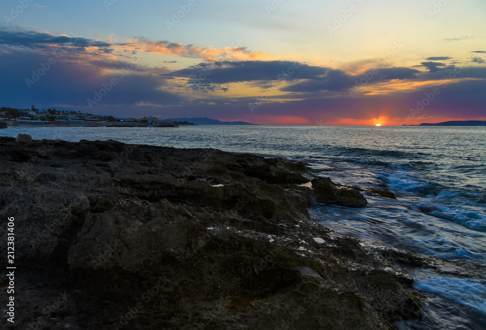 Beautiful mysterious marine landscape with resort town at sunset. Volcanic reef and ocean, Greek iseland Crete Beautiful mysterious marine landscape with resort town at sunset. Volcanic reef and ocean, Greek iseland Crete