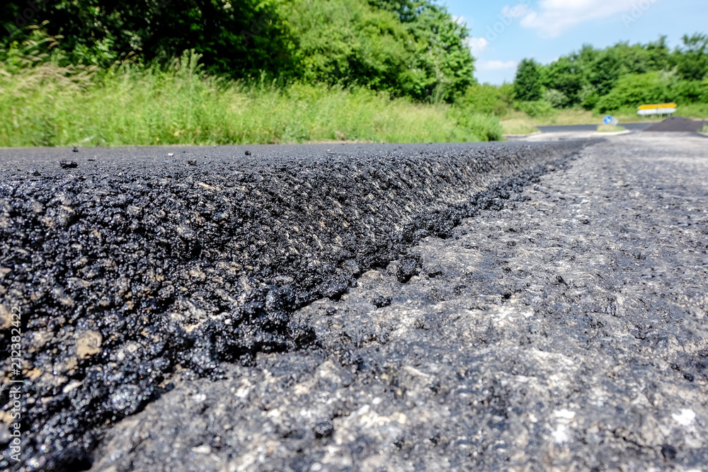 Straße erhält eine neue Decke aus Asphalt Straße erhält eine neue Decke aus Asphalt