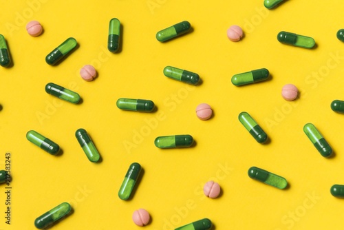 Capsule pills on yellow background. Medical pills. Pharmacy medicaments. © Djordje