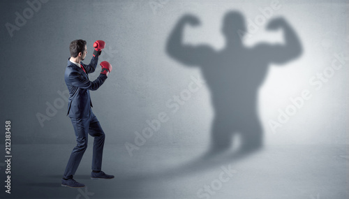 Businessman fighting with his bossy yelling shadow
