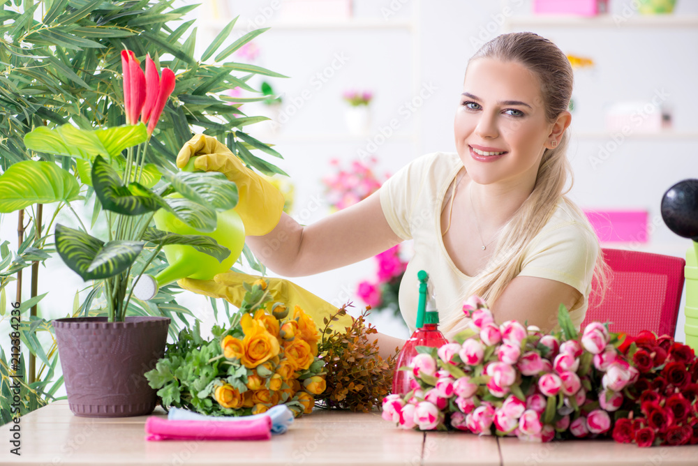Young woman watering plants in her garden Young woman watering plants in her garden