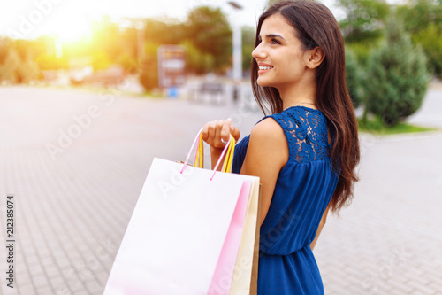 girl after shopping on the street, a Portrait of a woman holding paper bags, near the store