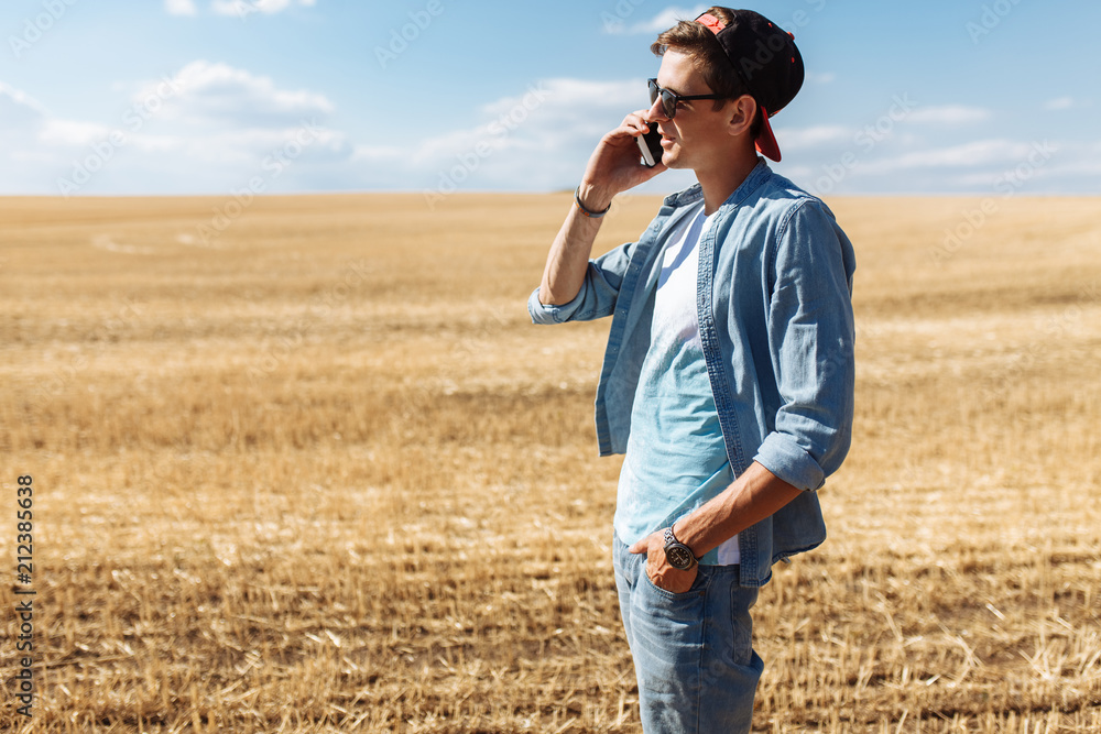 A man on the phone against a wheat field, a tourist walking on a wheat field, a portrait of a guy with glasses A man on the phone against a wheat field, a tourist walking on a wheat field, a portrait of a guy with glasses