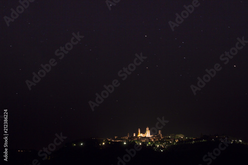 Starry night sky above the famous medieval town of San Gimignano, in Tuscany (Italy)
