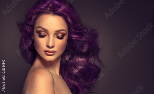 Beautiful model girl with long purple curly hair . Care products ,hair colouring . Treatment, care and spa procedures. Medium length hairstyle. Coloring, ombre, and highlighting . Hair coloring 