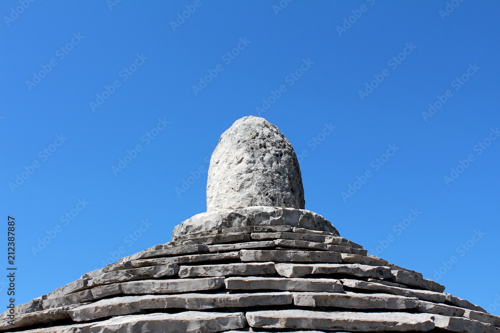 Traditional stone tiles structure top Kazun under clear blue sky on a warm sunny day
