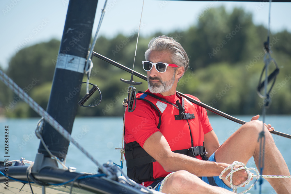 Naklejka premium young man sailing on hobie cat