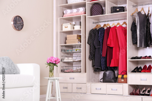 Modern wardrobe with stylish clothes in room interior © New Africa