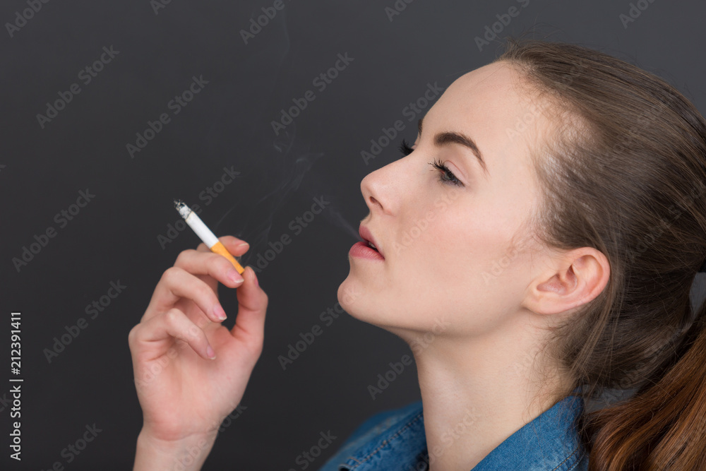 Obraz premium woman smoking slim cigarette