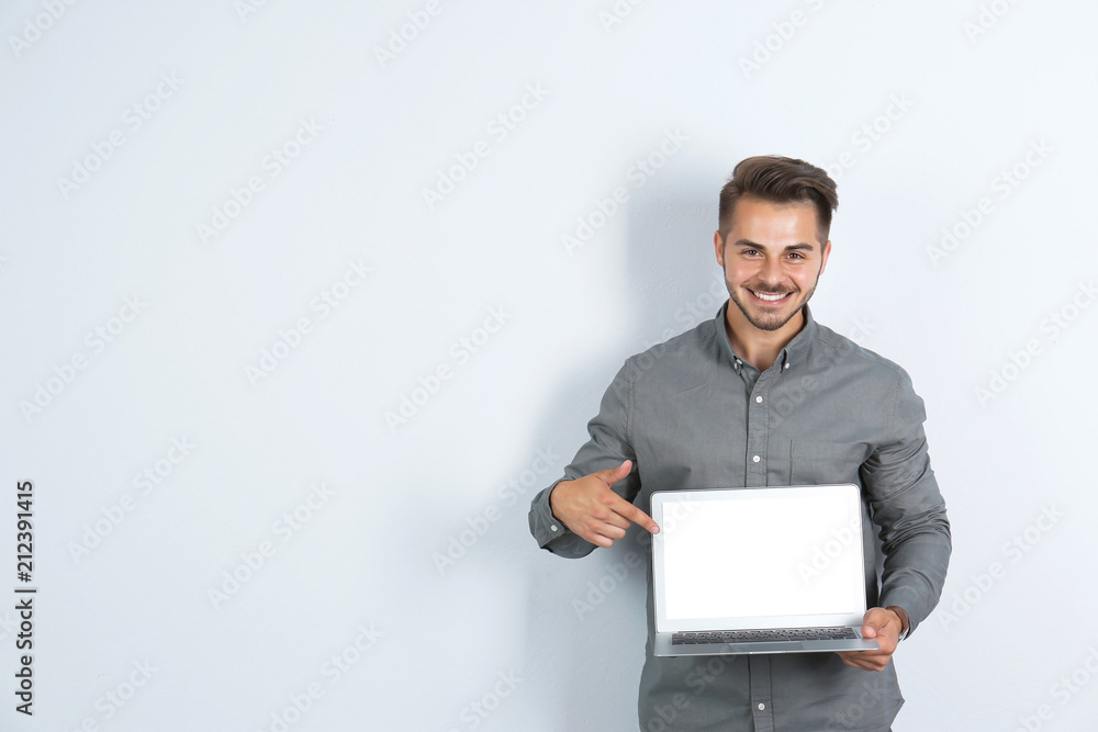 Man in casual clothes with laptop on light background Man in casual clothes with laptop on light background