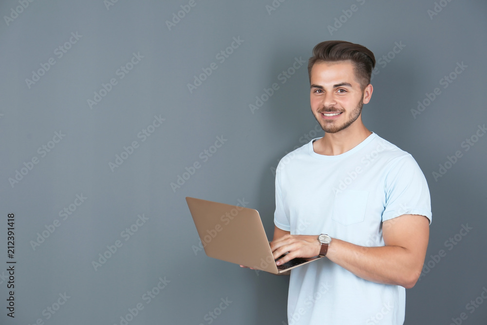 Man in casual clothes with laptop on color background Man in casual clothes with laptop on color background