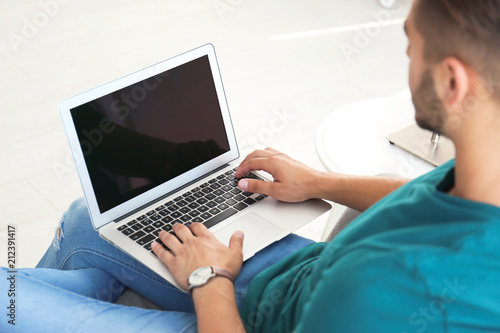 Man in casual clothes using laptop at home