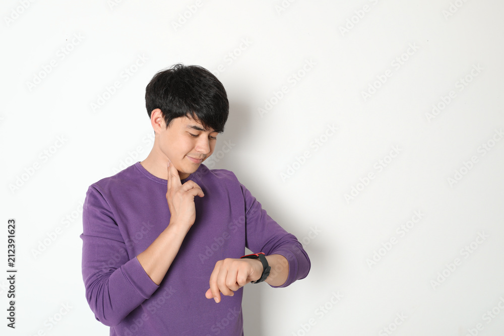 Young man checking pulse on light background Young man checking pulse on light background