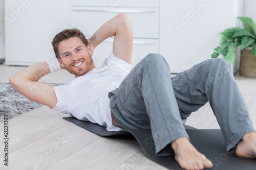 young man doing fitness exercises on a mat