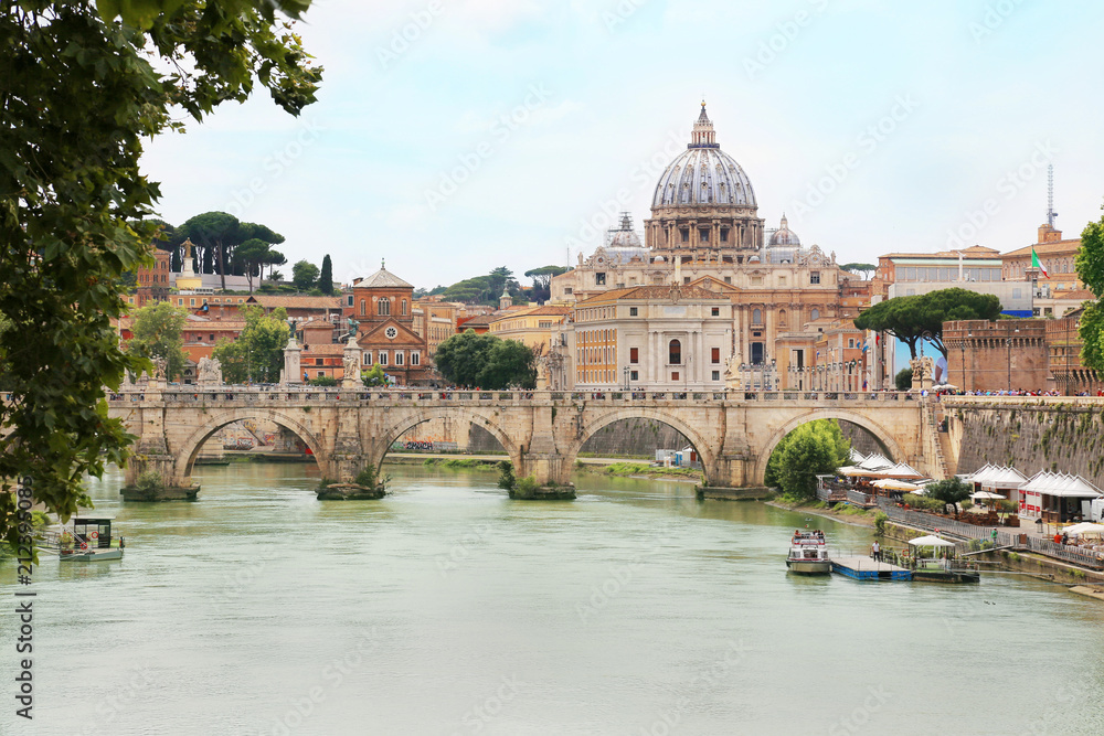 Ponte Sant' Angelo with St. Peter's Basilica in background across Tiber river in Rome, Italy