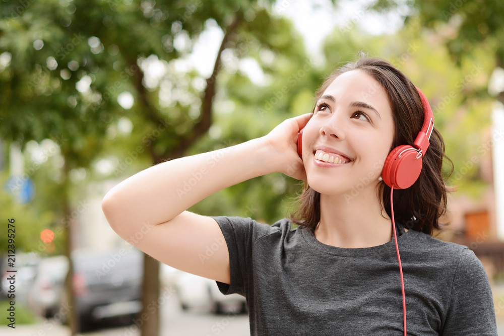 Portrait of young beautiful woman with red headphones listening music Portrait of young beautiful woman with red headphones listening music