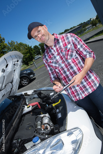 handsome man checking car engine