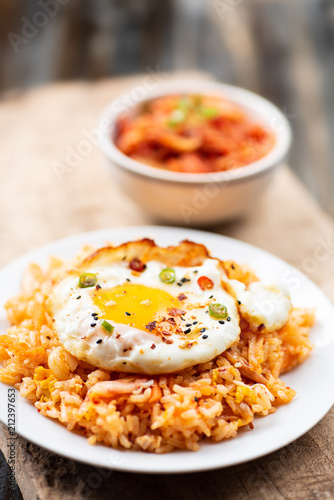 Kimchi fried rice with fried egg on top and fresh kimchi cabbage in a bowl, Korean food