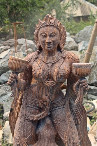 Beautiful/perfect sculpture of Dancing devadasi Holding musical instrument on her hand carved from red sand stone with natural background.An female servant of god or jogini is a girl.Odisha,July/7/18