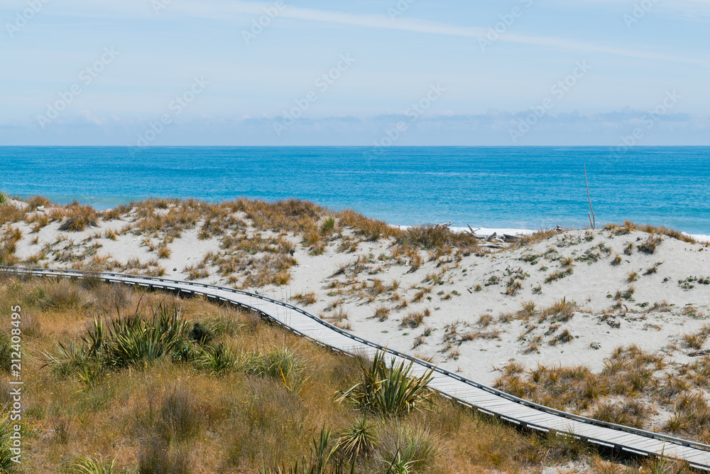Fototapeta premium Wooden walking path over ocean skyline background
