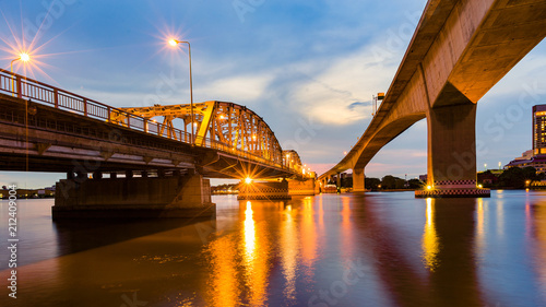 Metal bridge crossing river night view with reflection light