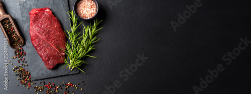 Raw beef steak with herbs and spices. Close up photo