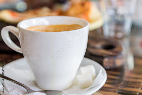 close up of white cup of cappuccino on table