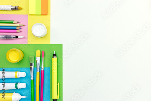 pencils, highlighters, brushes, erasers and colored album paper on white background