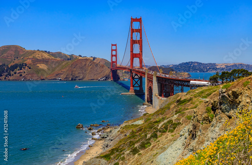 Photography Golden Gate bridge in San Francisco on a clear day with blooming flowers in the