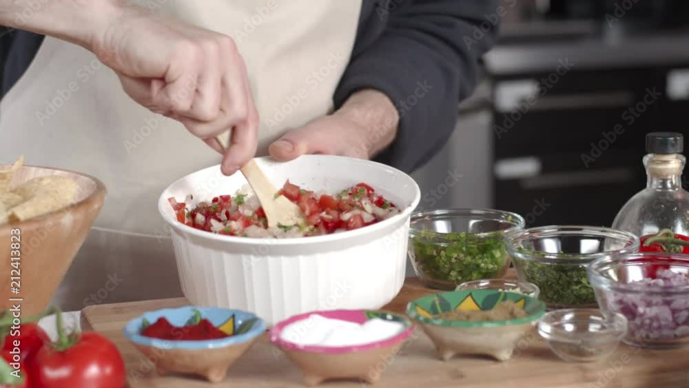 Slow-mo tracking shot of chef mixing ingredients in large white bowl Slow-mo tracking shot of chef mixing ingredients in large white bowl