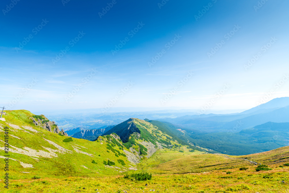 picturesque mountainside with green lawn, the Tatra Mountains and the top of Kasprowy Wierch, Poland