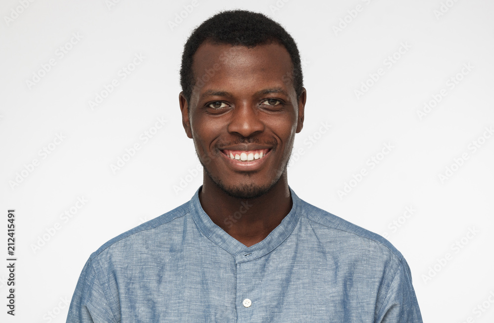 Close up portrait of smiling handsome african american man entrepreneur in blue shirt isolated on gray background Close up portrait of smiling handsome african american man entrepreneur in blue shirt isolated on gray background