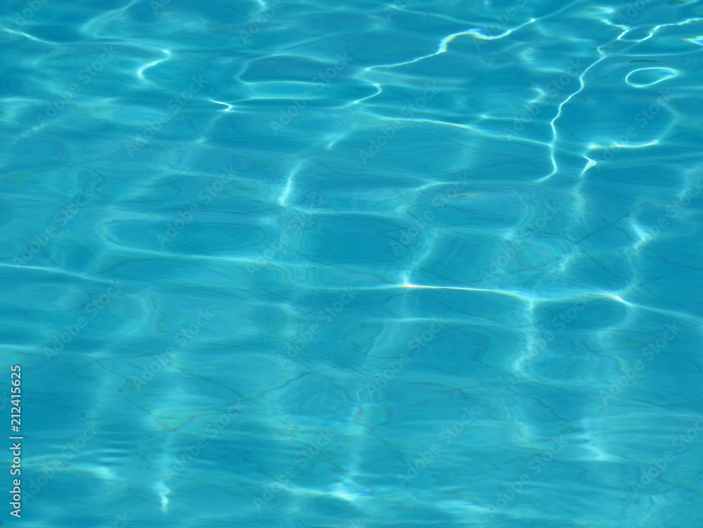 water surface of a swimming pool with sun reflections