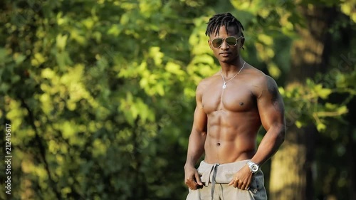 African macho man topless with naked torso in a park
