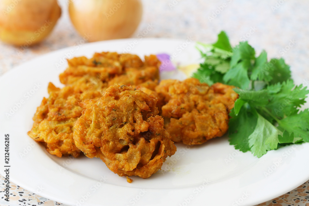 Indian pakoras on white place with fresh coriander leaves
Indian pakoras on white place with fresh coriander leaves